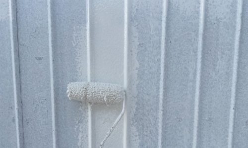 瀬戸市のトタン住宅で外壁塗装の下塗りを行う様子