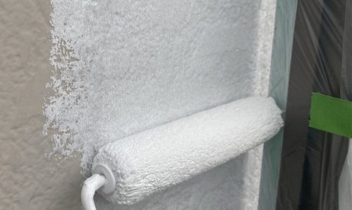 春日井市の住宅で外壁の下塗りを行っている様子