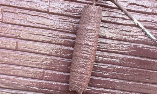 知立市の住宅で外壁に上塗りを行う様子