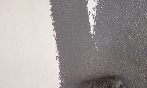 豊田市の住宅で外壁塗装の中塗りを行っている様子