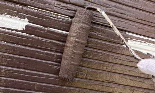 知立市の住宅で外壁に中塗りを行う様子