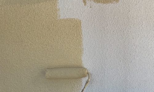 長久手市の住宅で外壁塗装の中塗りを行っている様子