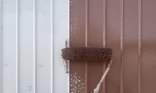 瀬戸市のトタン住宅で中塗りを行う様子