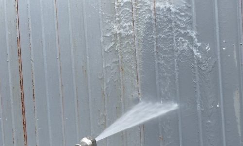 瀬戸市のトタン住宅で高圧洗浄を行う様子