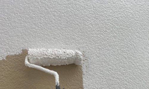 尾張旭市の住宅で外壁の下塗りを行っている様子