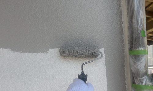 尾張旭市の住宅で外壁の中塗りを行っている様子