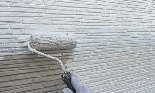 日進市の住宅の外壁に下塗りを行っている様子